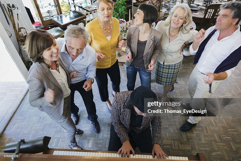 Donna matura ascoltando suona il pianoforte mentre amico