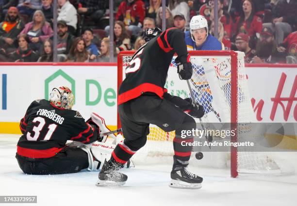 Jake Sanderson of the Ottawa Senators clears the puck off the line after a shot gets by Anton Forsberg as Owen Power of the Buffalo Sabres watches...