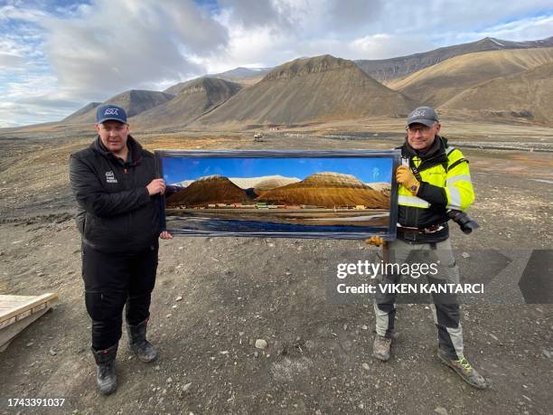 Picture shows former miner in charge of the rehabilitation project of the Svea mine Morten Hagen Johansen as he holds a picture of the mine in front...