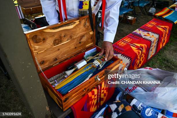 Man holds indigenous traditional accesories during a cultural meeting at the Comanche Nation fairgrounds in Lawton, Oklahoma on September 30, 2023....