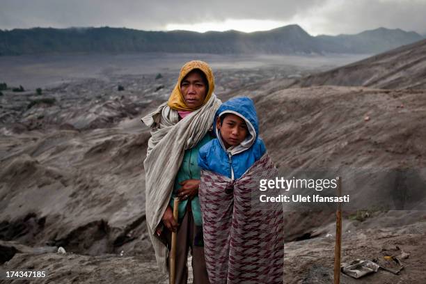 Snepi, with his son, Doni, stand at foot of Mount Bromo during the Yadnya Kasada Festival at crater of Mount Bromo on July 24, 2013 in Probolinggo,...