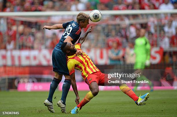 Toni Kroos of Muenchen competes with Alex Song of Barcelona during the Uli Hoeness Cup match between FC Bayern Muenchen and FC Barcelona at Allianz...
