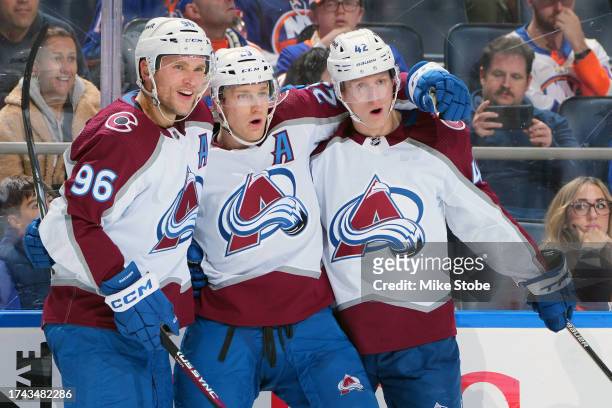 Nathan MacKinnon of the Colorado Avalanche is congratulated by Mikko Rantanen and Josh Manson after scoring a goal against the New York Islanders...