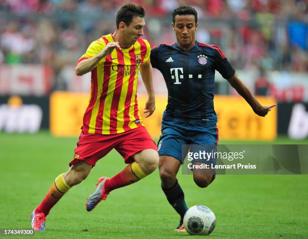 Thiago Alcantara of Muenchen challenges Lionel Messi of Barcelona during the Uli Hoeness Cup match between FC Bayern Muenchen and FC Barcelona at...