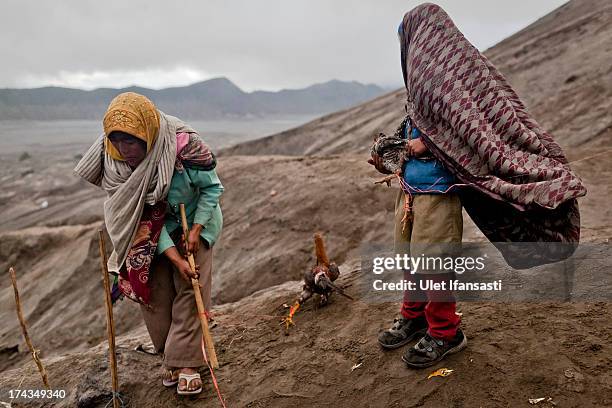 Doni, holds a chicken result of catch thrown by Hindu worshippers at foot of Mount Bromo during the Yadnya Kasada Festival at crater of Mount Bromo...