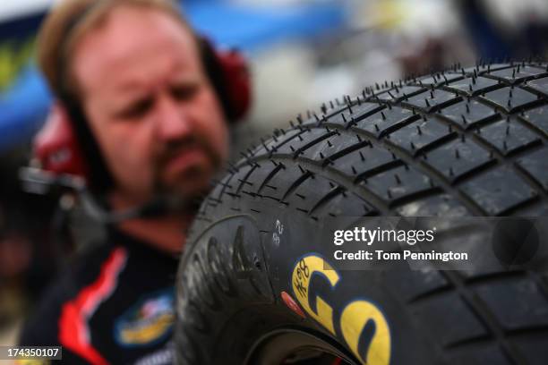 Crew members prepare their Goodyear Racing tire, made for dirt track racing, during practice for the NASCAR Camping World Truck Series inaugural...