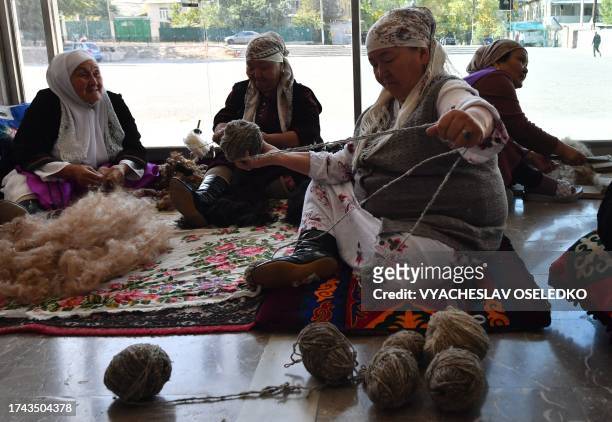 Group of older women calling themselves the "Happy Grandmas" work on weaving Shyrdaks - traditional Kyrgyz woollen rugs, at the House of Culture of...