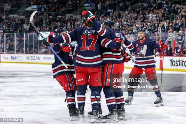 Neal Pionk, Adam Lowry, Nino Niederreiter and Brenden Dillon of the Winnipeg Jets celebrate a second period goal by teammate Mason Appleton against...