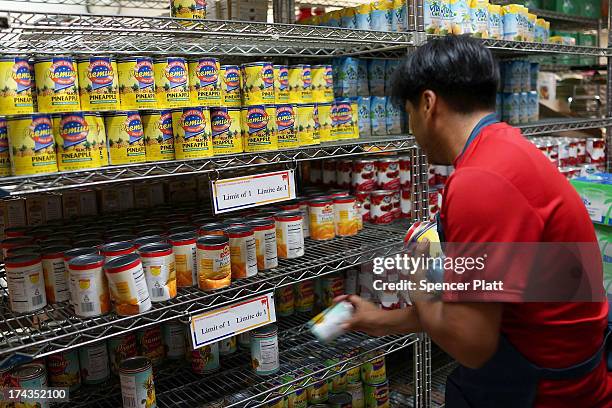 Volunteer stocks shelves at the West Side Campaign Against Hunger food pantry on July 24, 2013 in New York City. The food pantry assists thousands of...
