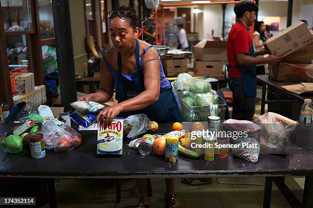 Volunteer Iysabel Rodriguez sorts food at the West Side Campaign Against Hunger food pantry on July 24, 2013 in New York City. The food pantry...