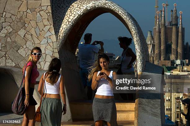 People take pictures from the roof of the building 'La Pedrera' or 'Casa Mila' of Antoni Gaudi with La Sagrada Familia on the background on July 24,...