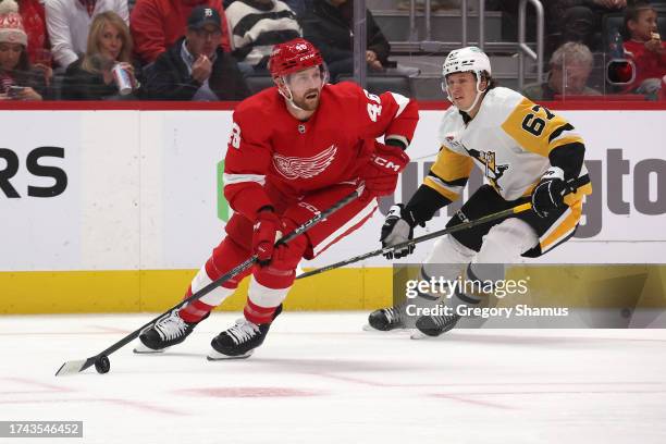 Jeff Petry of the Detroit Red Wings looks to pass away from Rickard Rakell of the Pittsburgh Penguins during the first period at Little Caesars Arena...