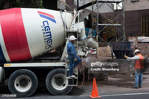 Worker on a Cemex SAB truck waits for the conveyor bucket to be put place before pouring concrete at a construction site in Mexico City, Mexico. On...