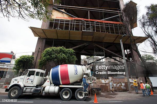 Worker on a Cemex SAB truck waits for the conveyor bucket to be put place before pouring concrete at a construction site in Mexico City, Mexico. On...