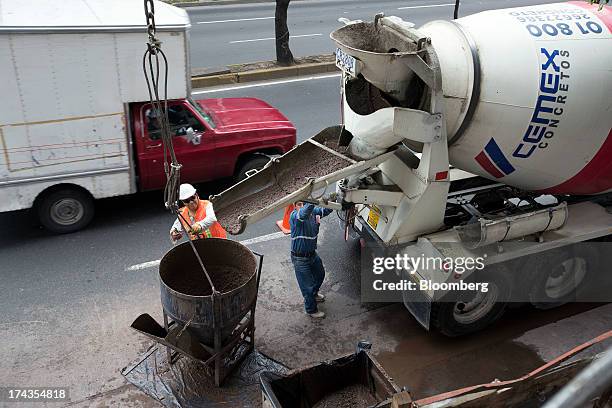 Workers pour concrete from a Cemex SAB truck at a construction site in Mexico City, Mexico. On Friday, July 19, 2013. Mexican President Enrique Pena...