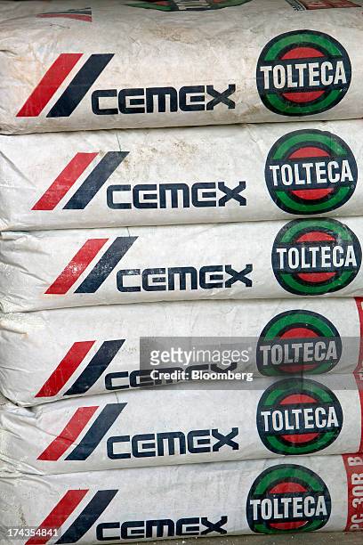 Bags of Cemex SAB's Tolteca brand cement sit stacked at a distribution center in Barrientos in the state of Mexico on Wednesday, July 24, 2013....