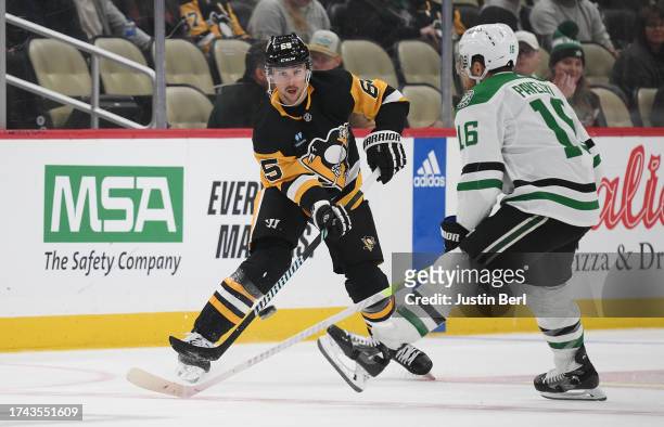 Erik Karlsson of the Pittsburgh Penguins moves the puck against Joe Pavelski of the Dallas Stars in the third period during the game at PPG PAINTS...