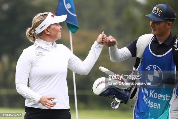 Nanna Koerstz Madsen of Denmark bumps fists with her caddie after sinking her putt for eagle on the second green during the first round of the BMW...