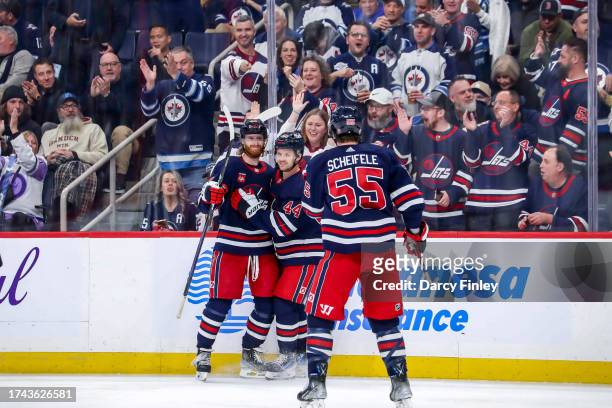 Kyle Connor, Josh Morrissey and Mark Scheifele of the Winnipeg Jets celebrate a third period goal against the St. Louis Blues at the Canada Life...
