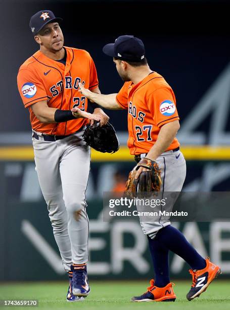 Michael Brantley of the Houston Astros celebrates with Jose Altuve of the Houston Astros after an out against the Texas Rangers during the sixth...