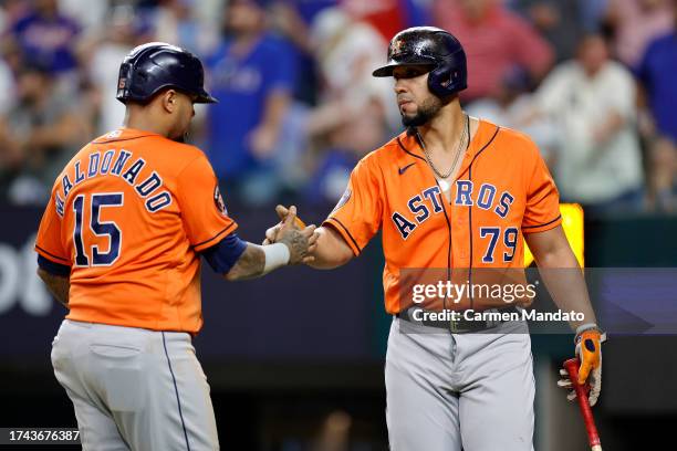 Martin Maldonado of the Houston Astros celebrates with Jose Abreu after scoring a run off a single hit by Yordan Alvarez against Will Smith of the...