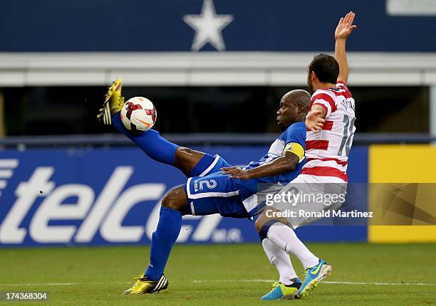 Osman Chavez of Honduras dribbles the ball against Landon Donovan of the United States during the CONCACAF Gold Cup semifinal match at Cowboys...
