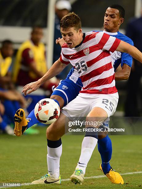 Matt Besler of the US vies for the ball from the sideline with Rony Martinez of Honduras during their Gold Cup semifinal soccer match in Arlington,...