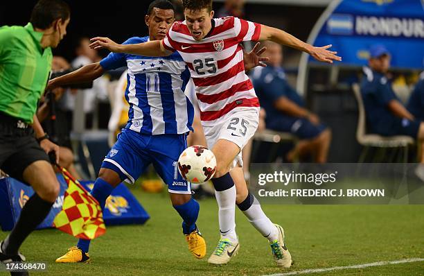 Matt Besler of the US vies for the ball from the sideline with Rony Martinez of Honduras during their Gold Cup semifinal soccer match in Arlington,...