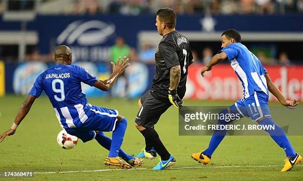 Goalkeeper Nick Rimando passes the ball upfield under pressure from Jerry Palacios and Rony Martinez of Honduras during their Gold Cup semifinal...
