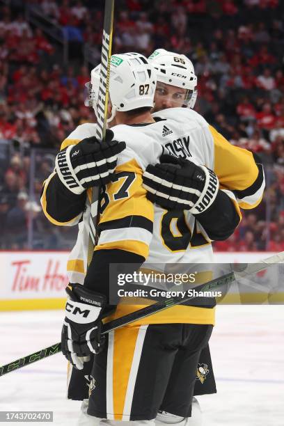 Erik Karlsson of the Pittsburgh Penguins celebrates his third period goal with Sidney Crosby while playing the Detroit Red Wings at Little Caesars...