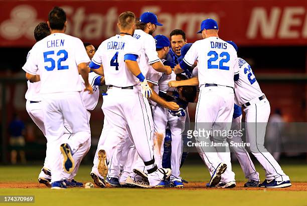 Alcides Escobar of the Kansas City Royals is congratulated byteammates after hitting a double to knock in the winning run during the bottom of the...