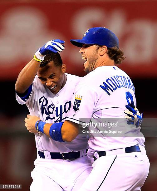 Alcides Escobar of the Kansas City Royals is congratulated by Mike Moustakas after Escobar hit a double to knock in the winning run during the bottom...