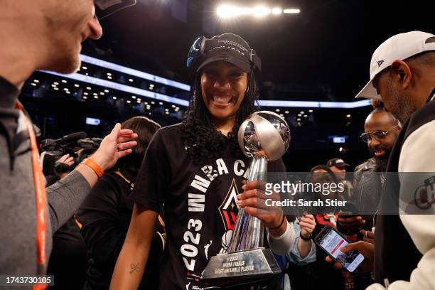 Ja Wilson of the Las Vegas Aces celebrates with the MVP trophy after defeating the New York Liberty during Game Four of the 2023 WNBA Finals at...