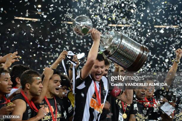 Brazilian Atletico Mineiro's players hold up the Libertadores Cup after their second leg final football match against Paraguayan Olimpia the Mineirao...