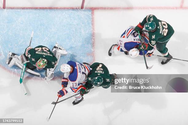 Filip Gustavsson, Brock Faber and Pat Maroon of the Minnesota Wild defend against Mattias Janmark and Mattias Ekholm of the Edmonton Oilers during...