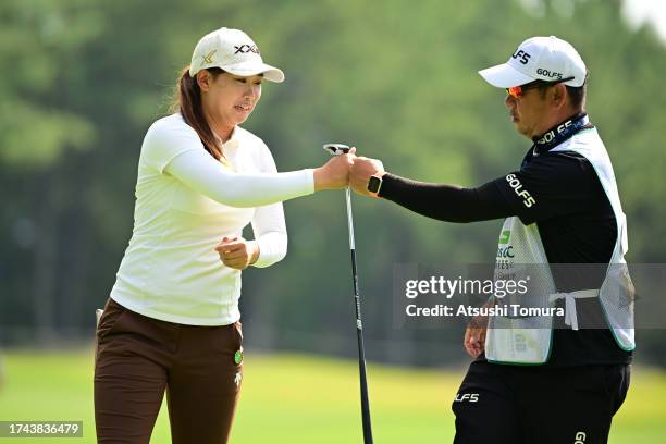 Reika Arakawa of Japan fist bumps with her caddie after the birdie on the 15th green during the first round of NOBUTA Group Masters GC Ladies at...