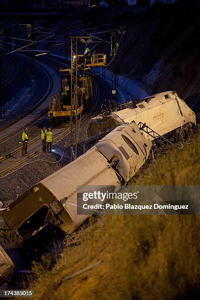 People work at the scene of a train crash that killed at least 77 people on July 25, 2013 at Angrois near Santiago de Compostela, Spain. The crash...