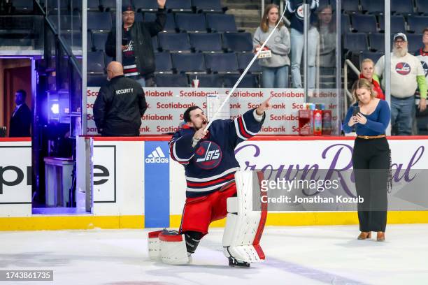Goaltender Connor Hellebuyck of the Winnipeg Jets hits the ice to celebrate after receiving first star honours following a 4-2 victory over the St....