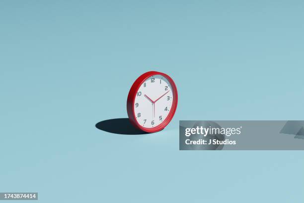 single red clock with a hard shadow - deadline abstract stock pictures, royalty-free photos & images