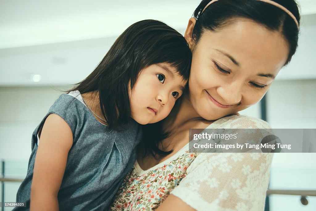 Smiling pretty young mom holding toddler girl