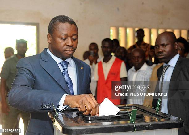 Togolese President Faure Gnassingbe tries to cast his vote to candidates of the ruling Union of the Republic in Lome on July 25, 2013. Voters in Togo...