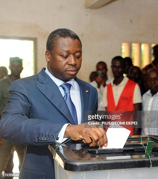 Togolese President Faure Gnassingbe tries to cast his vote to candidates of the ruling Union of the Republic in Lome on July 25, 2013. Voters in Togo...
