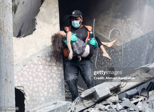 Palestinian emergency service staff rescues a victim in a building destroyed during Israeli air raids in the southern Gaza Strip on October 19, 2023...