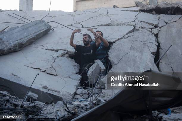 Palestinian emergency services and local citizens search for victims in buildings destroyed during Israeli air raids in the southern Gaza Strip on...
