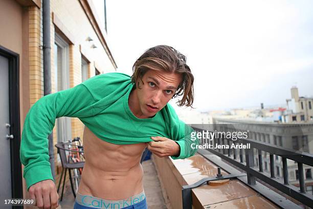 attractive young guy putting on shirt - only young men stock pictures, royalty-free photos & images