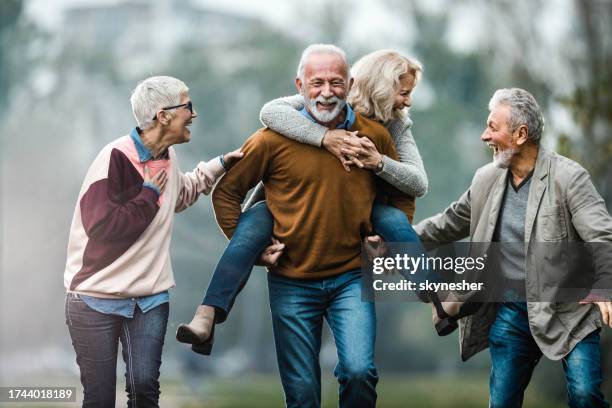 playful mature couples having fun during autumn day in nature. - activiteit bewegingloos stockfoto's en -beelden
