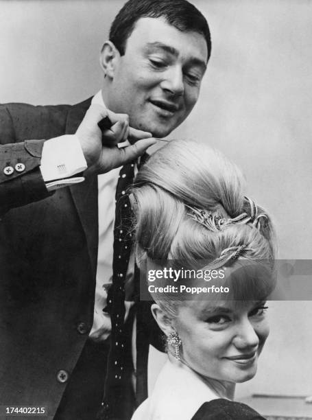 British hairdresser Vidal Sassoon styles the hair of South African opera singer Denny Dayviss at his salon in Old Bond Street, London, 25th April...