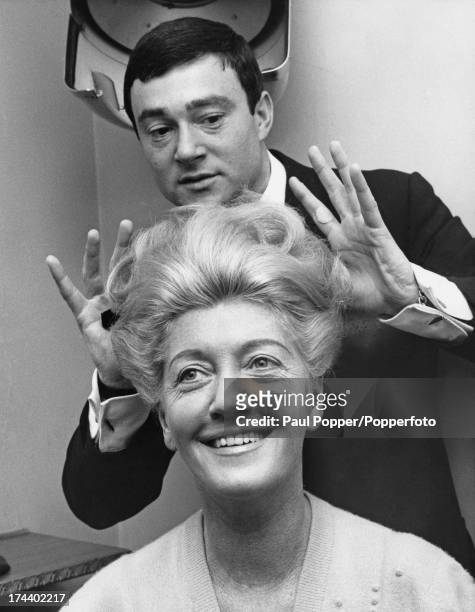 British hairdresser Vidal Sassoon styling the hair of client Mrs Wilding, at his salon in Old Bond Street, London, 23rd May 1963.