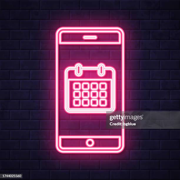 smartphone with calendar. glowing neon icon on brick wall background - night time routine stock illustrations