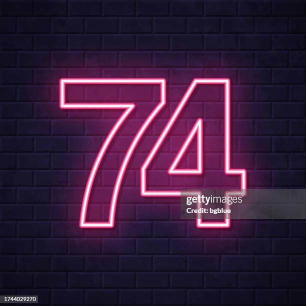 74 - number seventy-four. glowing neon icon on brick wall background - number 74 stock illustrations